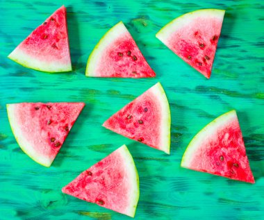 Ahşap zemin üzerinde dilimlenmiş karpuz.
