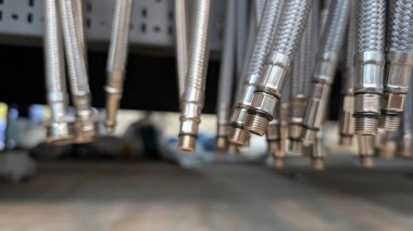 Detail of highquality metallic hoses showcasing various connectors, perfect for plumbing or machinery applications