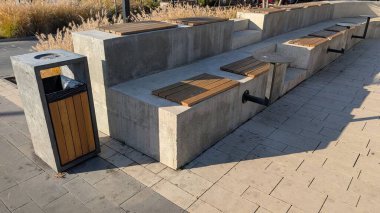 Tahta Toplar ile beton banklar yürüyüş yolu boyunca hizalanır, çöp tenekesi yakında, Form ve Uzun Gölgeler Oluşturma Meşgul Sivil