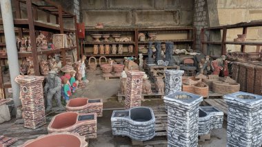 Çömlek rafları, heykeller ve dekoratif ekiciler, çeşitli seramik stil ve renklere sahip kapalı sergi, sanatsal figürler