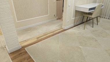 Ahşap halı, ahşap kaplama ve halı arasında zarif bir zemin geçişi. Temiz süsleme ve ince pervazlarla birleşir.