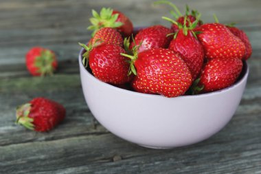 Ahşap arka plan üzerinde kapta iştah açıcı taze sulu çilek