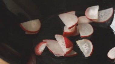 Turp dilimleri siyah salata kasenin içine düşmek