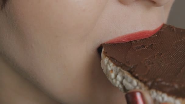 Ragazza con labbra rosse e unghie mangia pane tostato con cioccolato fatto in casa nocciola diffusione — Video Stock