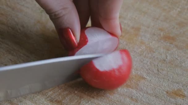Meisjes handen met rode nagels snijd de radijs in plakjes — Stockvideo