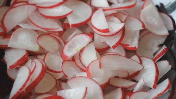 Skivor av gurka falla i salladsskål fylld med skivor av rödaktig — Stockvideo