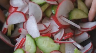 Kızlar el kırmızı çivi ile dilim turp ve salatalık salatası kase mix