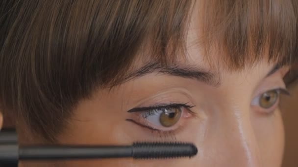 Söt flicka målar sin ögonfransar — Stockvideo