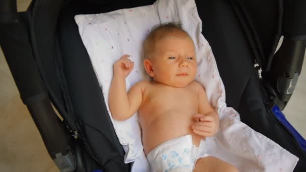 Νεογέννητο μωρό φτερνίζεται στο παιδικό κάθισμα. — Αρχείο Βίντεο