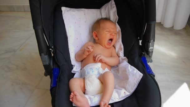 Pasgeboren baby geeuwen in de autostoel — Stockvideo