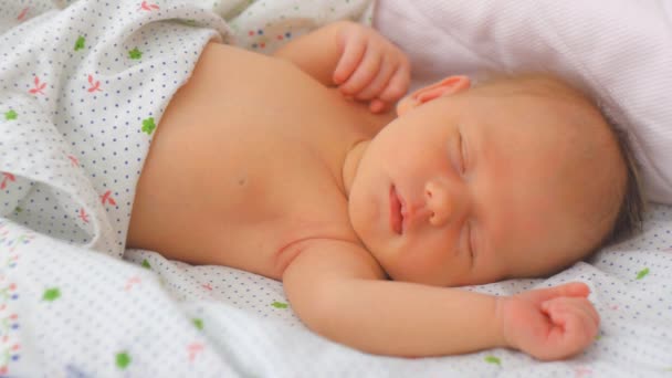 El bebé recién nacido hace caras durante el sueño de movimiento rápido de los ojos — Vídeo de stock