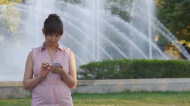 Genç kadın gülümseyerek telefonu masaj yazıyor
