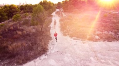 Gün batımında koşan genç kadın.