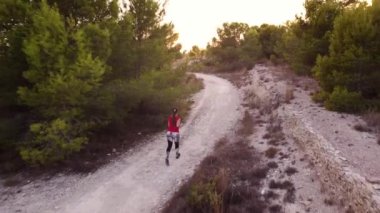 Gün batımında koşan genç kadın.