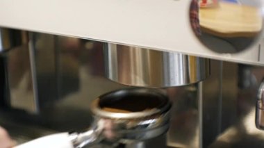 Tutacağı kahve makinesine koyuyorum.