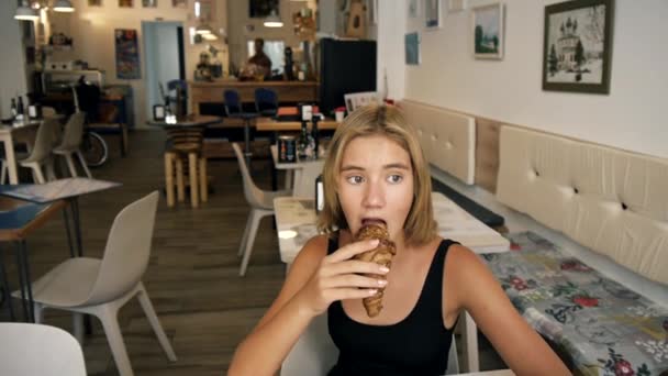 Mädchen isst Croissant — Stockvideo