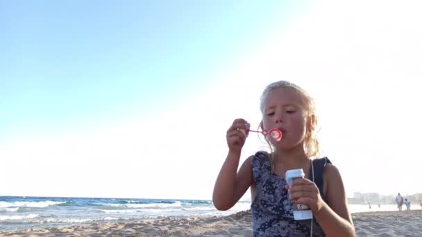 Kind pustet Seifenblasen am Strand — Stockvideo