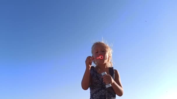 Kind pustet Seifenblasen bei Sonnenuntergang — Stockvideo