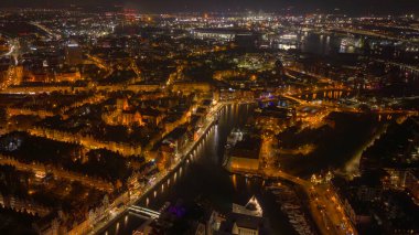 Gdansk Eski Kasabası 'nın, Motlawa Nehri' nin gece görüşü köprüleri ve rıhtımları yansıtır. St. Marys Kilisesi ve Gdansk Turnası Polands Baltık sahilinde parlayan tersaneler gibi duruyor..