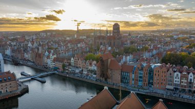 Günbatımında Polonya 'nın Gdansk kentinin havadan görünüşü Motlawa Nehri, Zuraw vinci, St. Marys Kilisesi ve belediye binasının ışığın yayalar ve kanolarla suya yansıdığını gösteriyor..