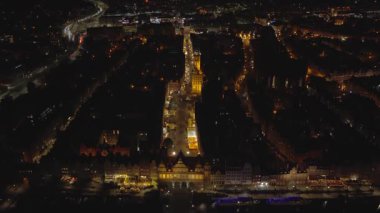Gdansk Old Town ve Motlawa üzerinde hava kayması, Long Market ana kasaba kulesine, St. Marys Kilisesi sağda, sıcak ışıklar kontrastlı karanlığa, demirli teknelere götürür..