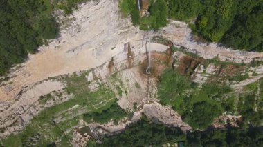 Havadan bakıldığında, Gürcistan 'da Svaneti koridoru yakınlarındaki eğimli bir kireçtaşı uçurumunda bir şelale görünüyor. Uçurum inişi, dalış havuzları, dere kanalları ve geçitleri var..