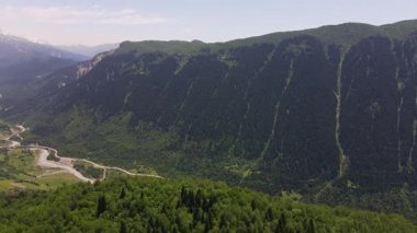 Hava görüntüsü Gürcistan 'daki Svaneti Vadisi' ni gösteriyor. Solgun bir nehir, Ushba Dağı 'na doğru çayırları ve köyleri geçiyor. Kozalaklı kayalıklar, otlaklar ve erozyon vadileri var..