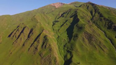 Gürcistan 'daki Svaneti dağlık arazilerindeki hava aracı atışları otlak alp yamaçları, derin vadiler, ince çağlayanlar, kayalık kaburgalar ve ılık düşük güneş ışığı altında uzak kar örtülü zirveler gösteriyor.