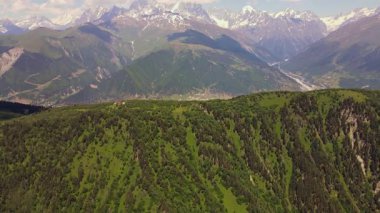 Hava aracı Gürcistan 'daki Kafkasya' nın merkezine doğru ilerlerken Mestia 'nın Ushguli vadisine, örülmüş nehre, çayırlara ve kırmızı bir çatı kulübesine ulaştığını gösteriyor..