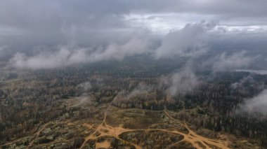 Hava görüntüsü Dretunsky 'nin Belarus' taki eğitim alanını gösteriyor, karışık ormanlık, alçak bulutlar, kumlu raylar, temizlenmiş pedler, ve sonbaharın sonlarında bulutlu ışık altında bir sığınak tümseği..