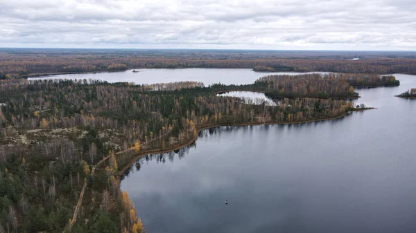 Dretunsky 'nin Belarus' taki orman yarımadaları ve adaları, sonbahar huş ağaçları, kozalaklı ağaçlar, kumlu yollar ve sakin bir göl üzerindeki yalnız bir tekne eğitim sahası..