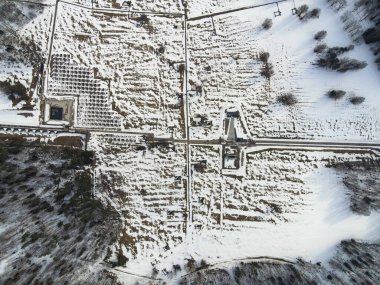 Belarus 'un hava görüntüsü, karla kaplı bir ızgara, merkez çapraz yol, solda kare beton bloknotlar ve kış güneşinde izole edilmiş yapılar gösteriyor..