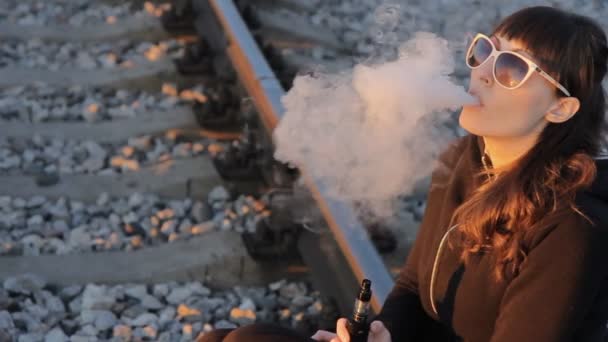 Mädchen sitzt auf der Bahn und raucht — Stockvideo