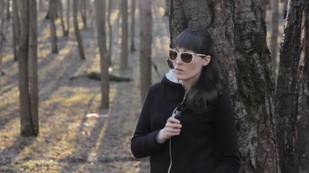 Chica joven en gafas de sol fumando el cigarrillo electrónico — Vídeos de Stock