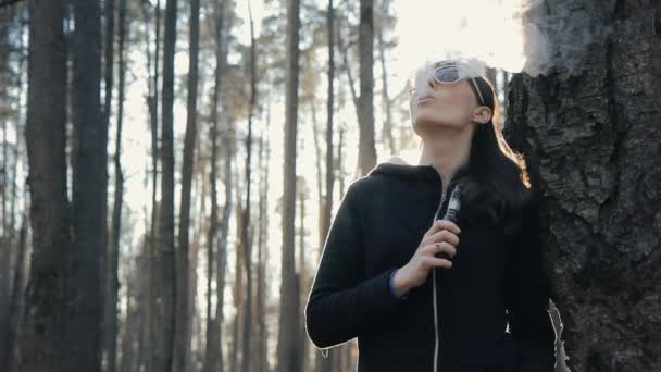 Dívka v parku kouření elektronické cigarety — Stock video