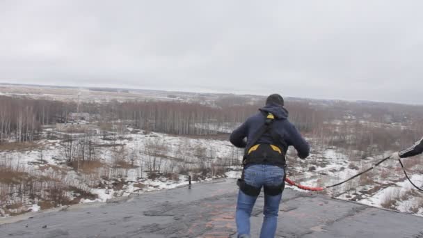 Мужчина прыгает с крыши с веревкой, куколкой — стоковое видео