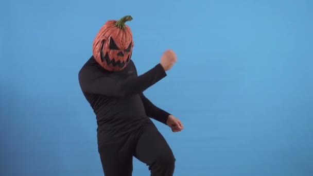 Танцующий тыквенный человек на синем фоне — стоковое видео