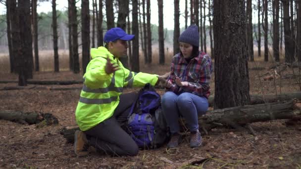 救助隊員が森の中で迷子になった女性を金の救助毛布で覆い — ストック動画
