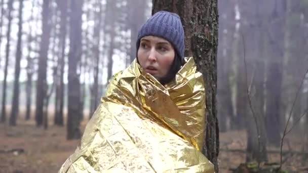 Close up lost hiker woman wrapped on golden survival blanket — Stock Video