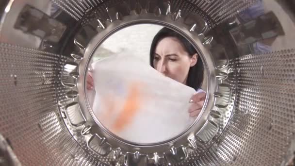 Zaskoczona młoda kobieta wyjmuje pralnię z plamą z pralki — Wideo stockowe