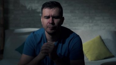 Karanlık odada ağlayan üzgün bir adamın portresi.