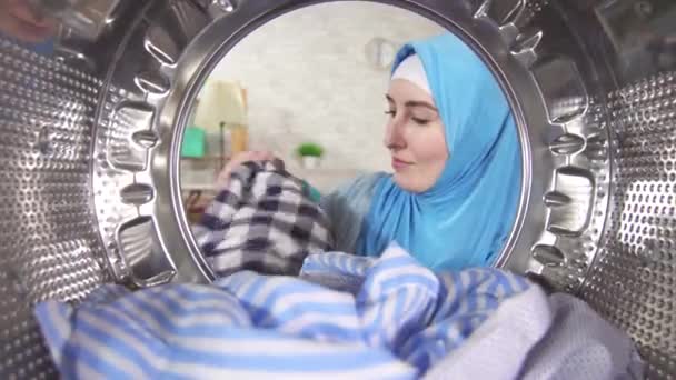 Jovem muçulmano mulher leva limpo Lavandaria fora da máquina de lavar roupa — Vídeo de Stock