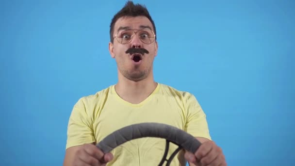 Lustiger Mann verunglückt und knallt mit dem Kopf auf das Lenkrad vor blauem Hintergrund — Stockvideo
