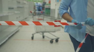 boş rafların arka planında bir kaset ve bir alışveriş arabası var.