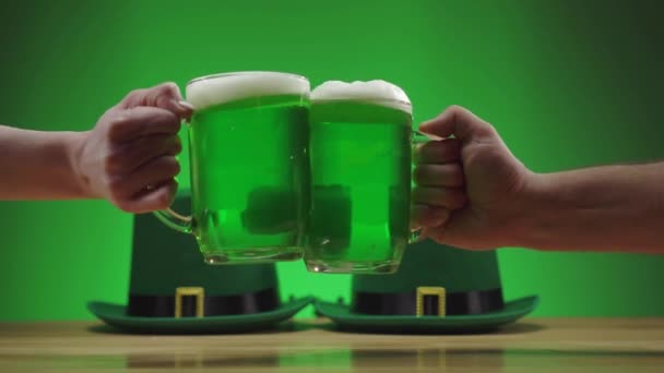 Deux tasses de bière mousseuse verte clignent sur un fond vert St. patricks jour — Video