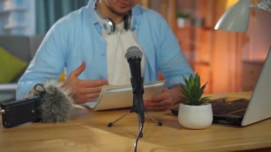 Tanınmayan bir kişi evde otururken bir ses yayını kaydeder veya bir internet yayını yönetir