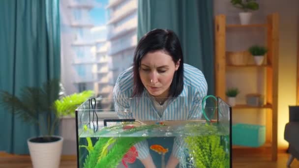 Jeune femme perplexe recherche des informations sur l'aquarium dans son smartphone — Video