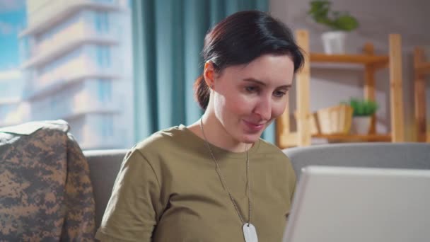 Portré fiatal mosolygós katonai nő ül a laptopján — Stock videók