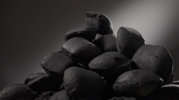 Slow rotation a pile of charcoal in briquettes — Stock Video