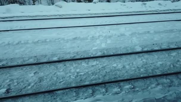 電車の窓から線路の上を眺めます 鉄道のレールに沿って動きます 冬の天候 — ストック動画